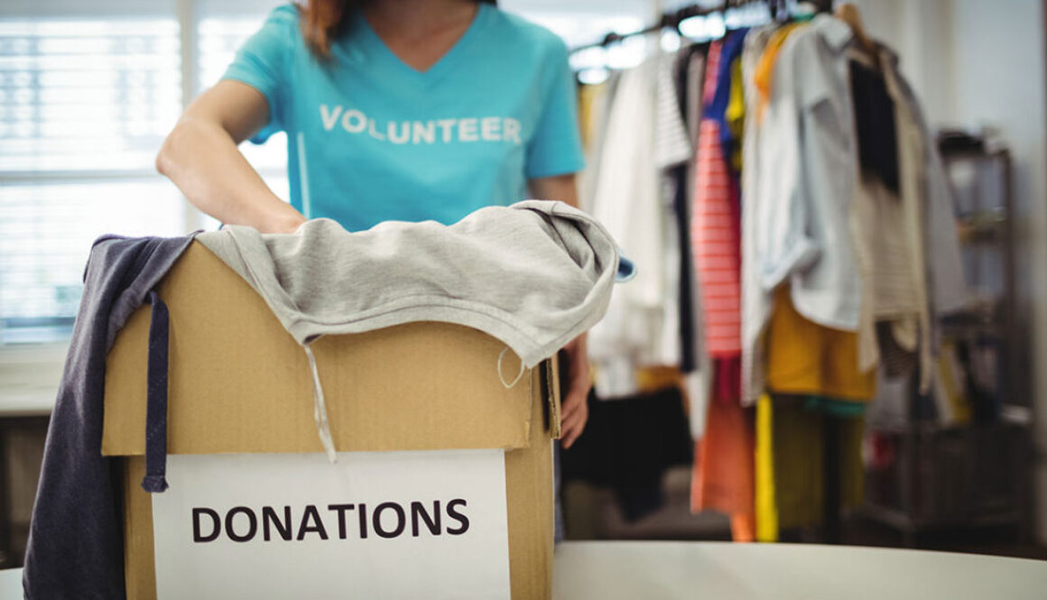 female-volunteer-holding-clothes-in-donation-box